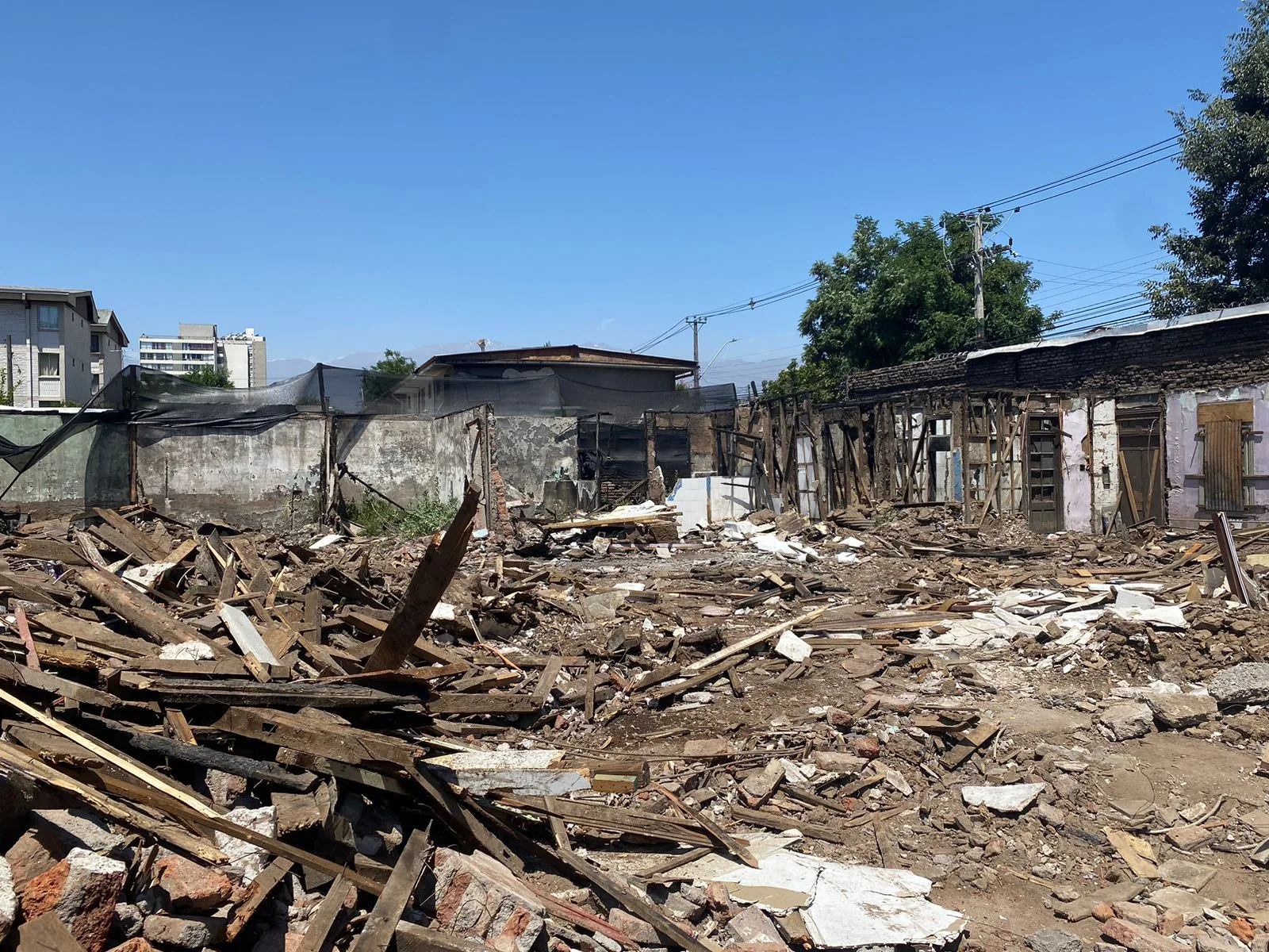 Demolición de viviendas antiguas de madera y albañilería, con escombros en el terreno